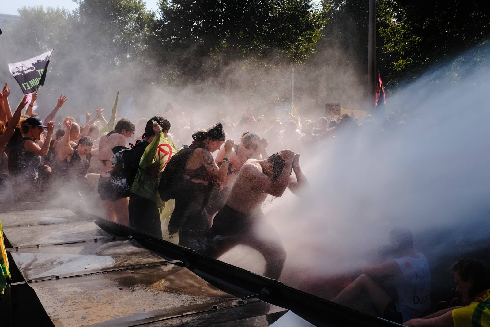 Rebels brace themselves as they are hit by a torrent of water from a police cannon