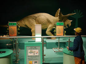 Kid pressing a button at the Farting Triceratops display