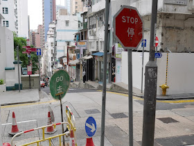 "go" sign placed behind a "stop" sign at a street corner in Hong Kong