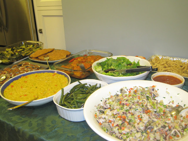  fish salad, risotto Milanese, string beans, green salad, fried calamari, baked clams, and bacalla in tomato sauce