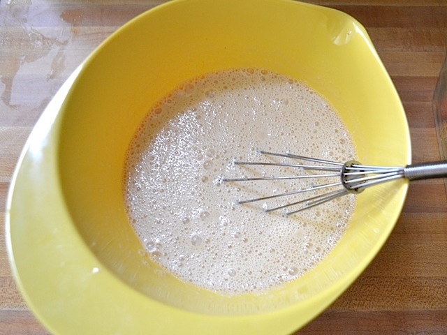 wet ingredients in yellow mixing bowl with whisk 
