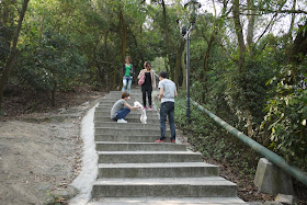 People with a dog on the stairs up a hill at Jingshan Park in Zhuhai, China
