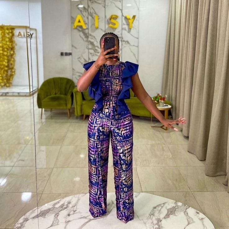 A woman in ankara top and pants taking a selfie in the mirror