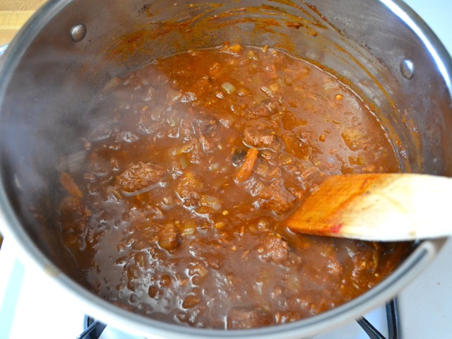 finished stew in pot with wooden spoon 