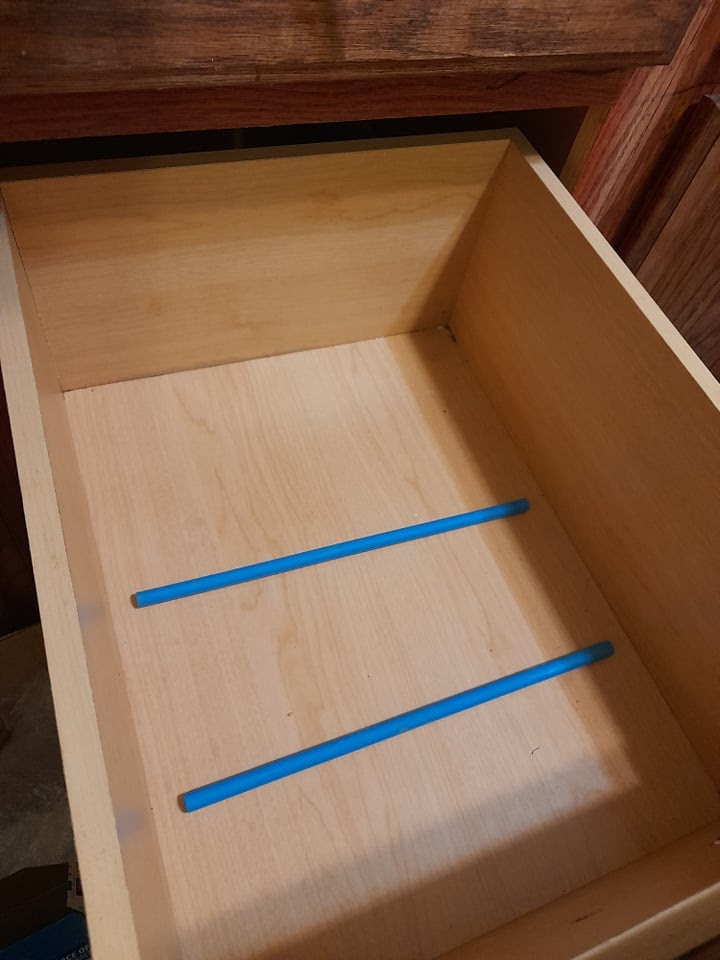 dowel rods secured in the drawer with hot glue. 