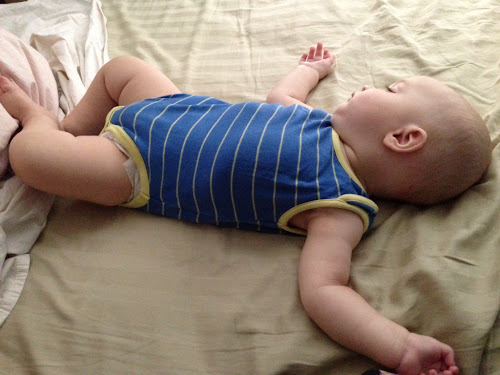 Fast asleep on out bed. On back, arms out.