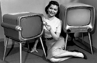 Girl sitting next to retro TVs