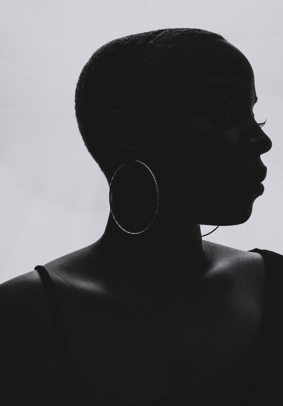 Semi silhouette of a beautiful, shaved head black woman wearing big hoops. Photo by Embodied Art Boudoir. Classic boudoir photography, classic photography, classic boudoir, classy boudoir, classy photography, colorado boudoir, denver boudoir, boulder boudoir, colorado springs boudoir, boudoir ideas, boudoir poses, boudoir inspiration, photography inspiration, boudoir session, boudoir photos