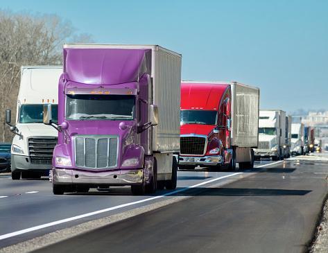 https://media.istockphoto.com/id/1384341522/photo/multi-colored-convoy-of-big-trucks-rolls-down-the-interstate.jpg?b=1&s=170667a&w=0&k=20&c=YrUF3TL93-_puFabJDAN87OP1P6uKycu6tsFVRl7dhs=