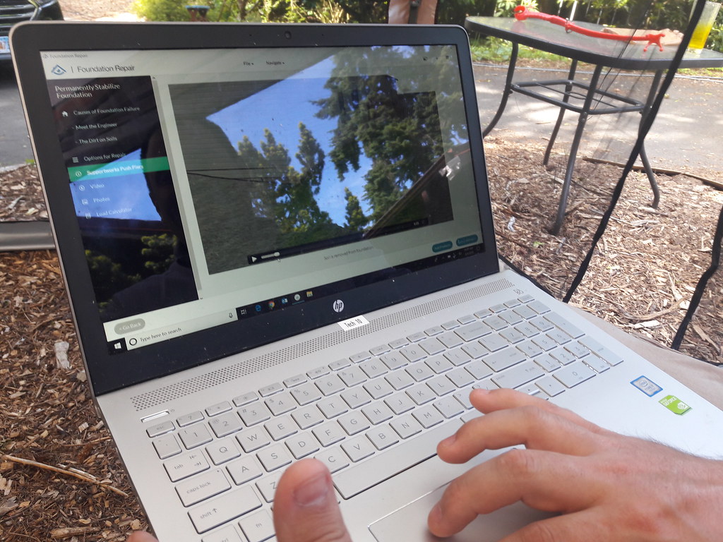 HP Envy x360 laptop in the hands of man with open display in the outground.