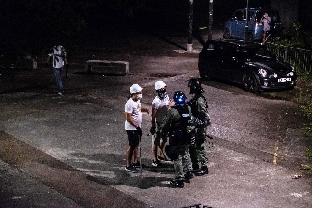 7月21日,香港警方在元朗与手持武器的男子讲话。不久后,一群亲中国的暴徒在火车站袭击人群。