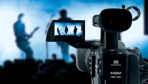 A HDV camera recording some musicians on stage: Music video budget