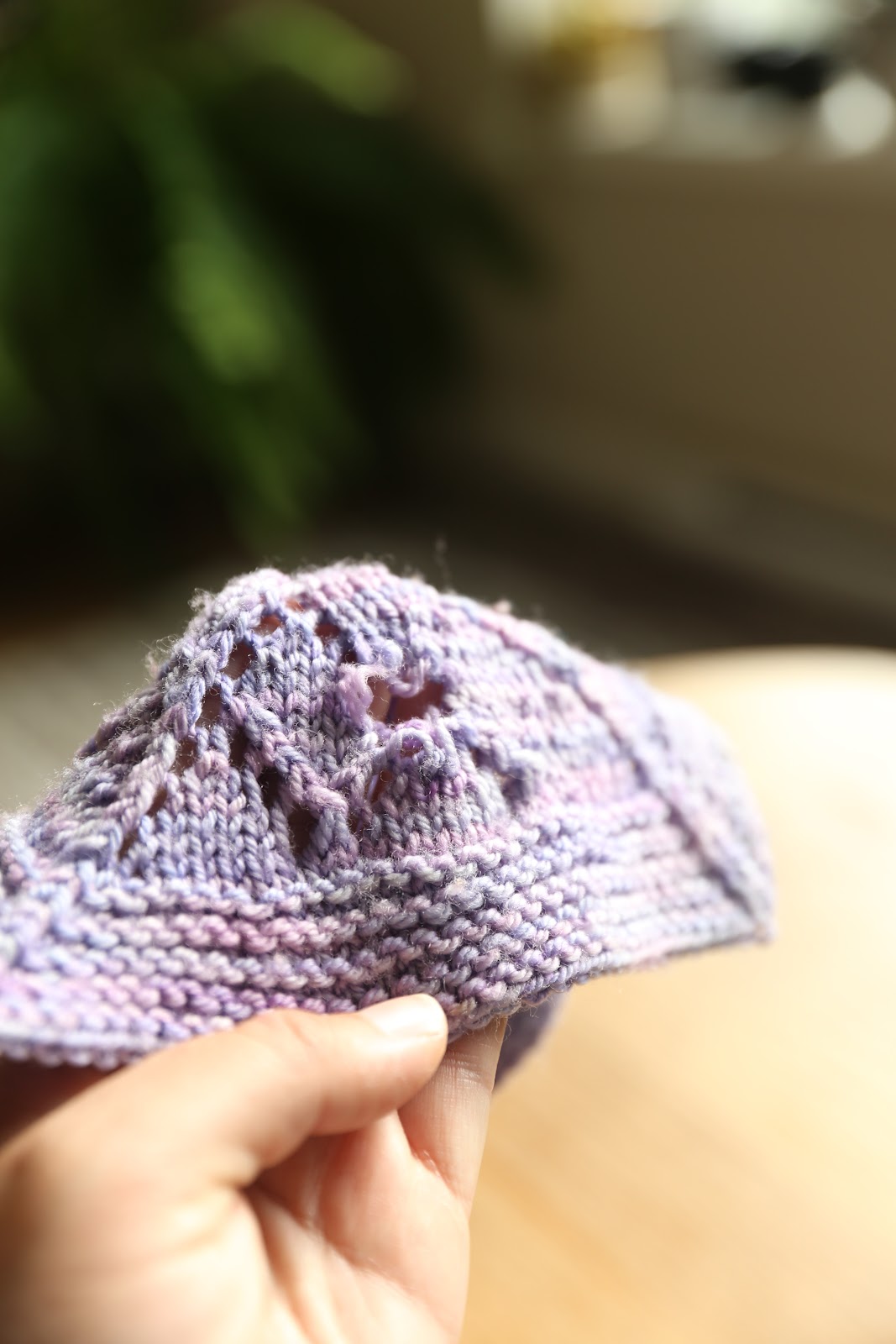 I am holding a lavender lace balnket square with a big hole in it.