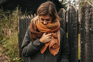 woman wearing orange reversible knitted scarf outside