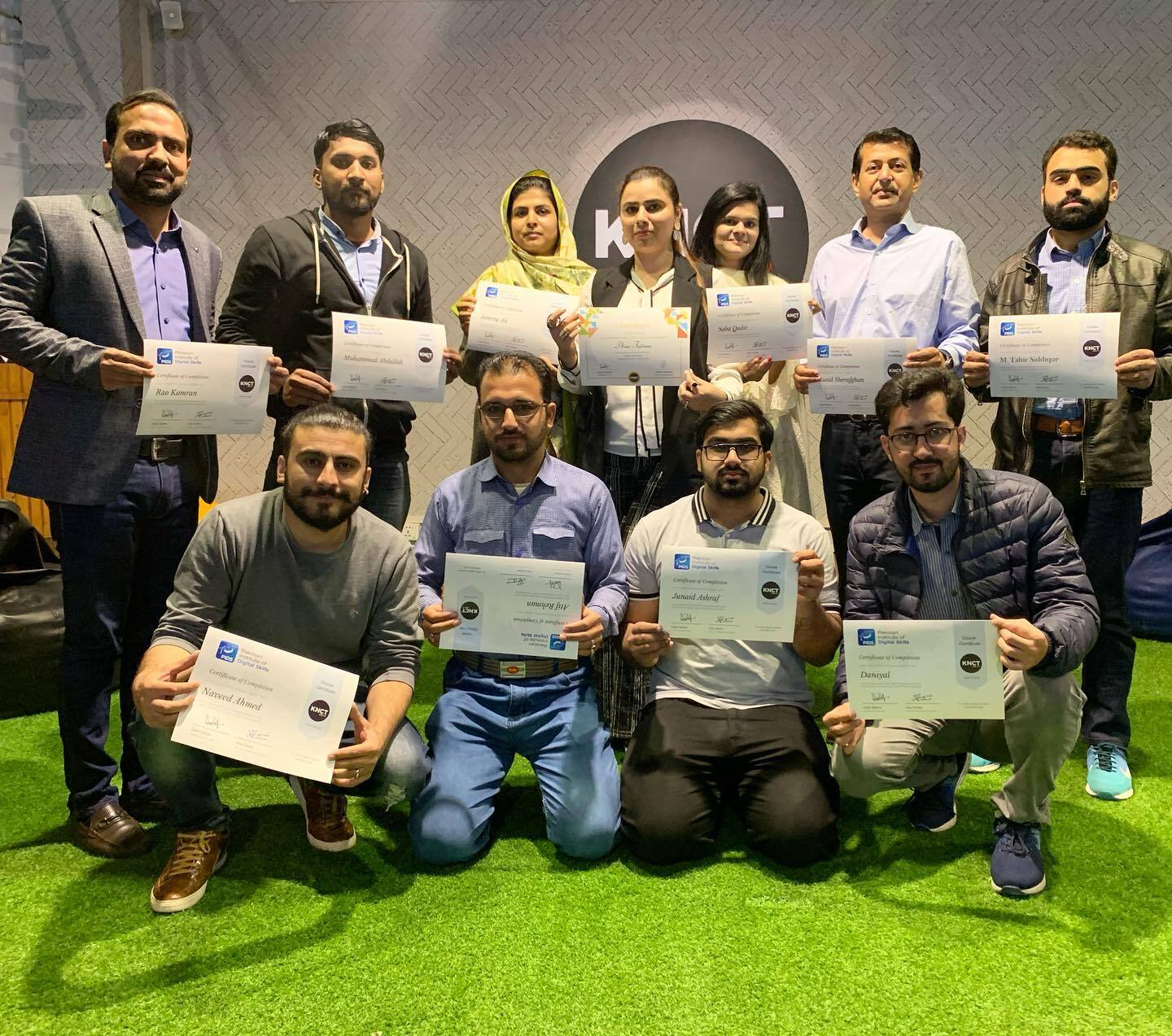 Group of employees holding diplomas in their hands.