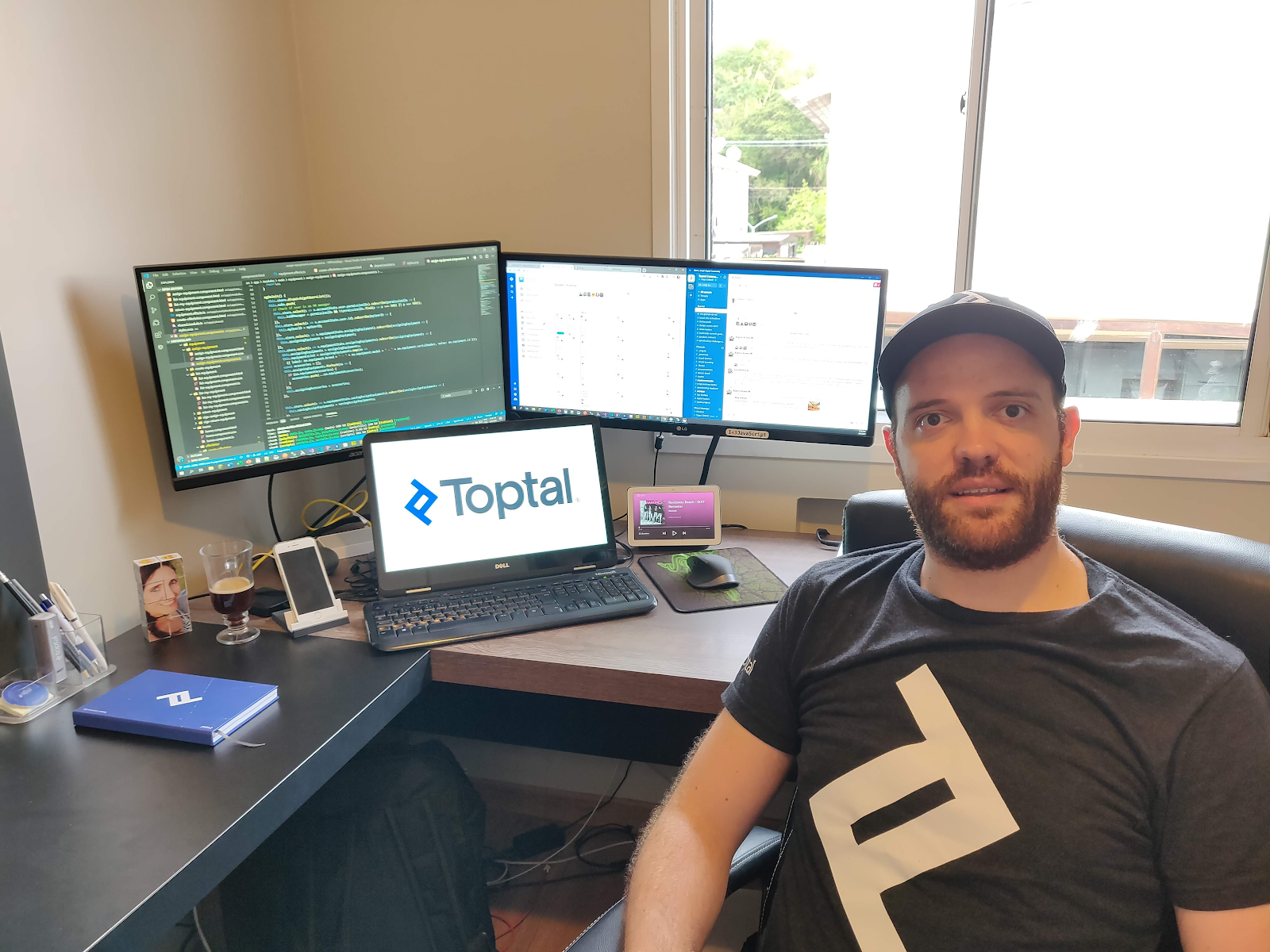 Tiago Chilanti, developer at Toptal, sitting at his remote workspace, bright daylight showing through the window behind him