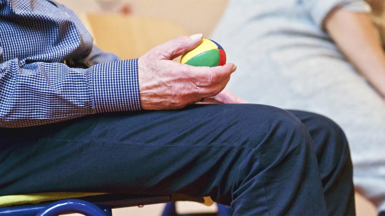 An Elderly Gentleman Holding a Colorful Ball