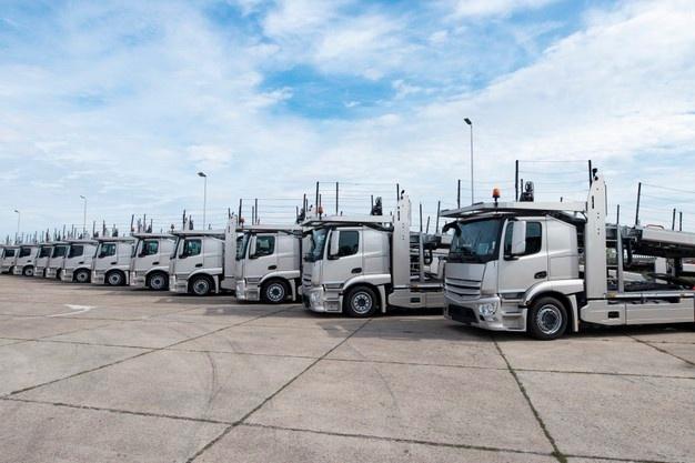 Group of trucks parked in line at truck stop Free Photo