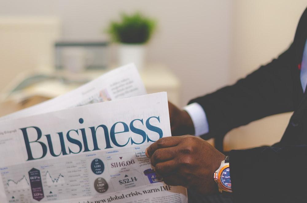 A man reading about the stock market in a business newspaper