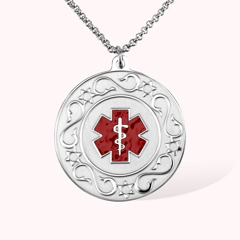 Médaille d’alerte médicale portant une étoile de vie de couleur rouge avec le bâton d’Asclépios sur fond blanc. Le pourtour est décoré de 5 étoiles séparées par une forme de S esthétisée.