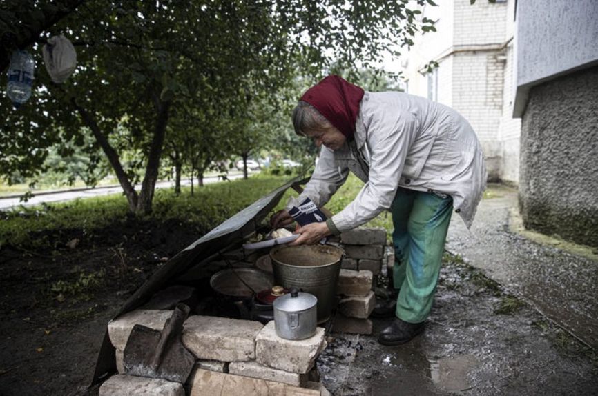 Мешканка Куп'янська готує їжу біля під'їзду багатоповерхівки