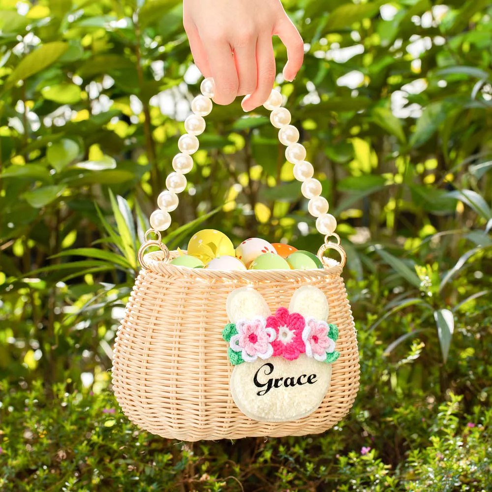 Panier de Pâques en rotin avec anse en perles et tête de lapin fleurie personnalisée d’un prénom.