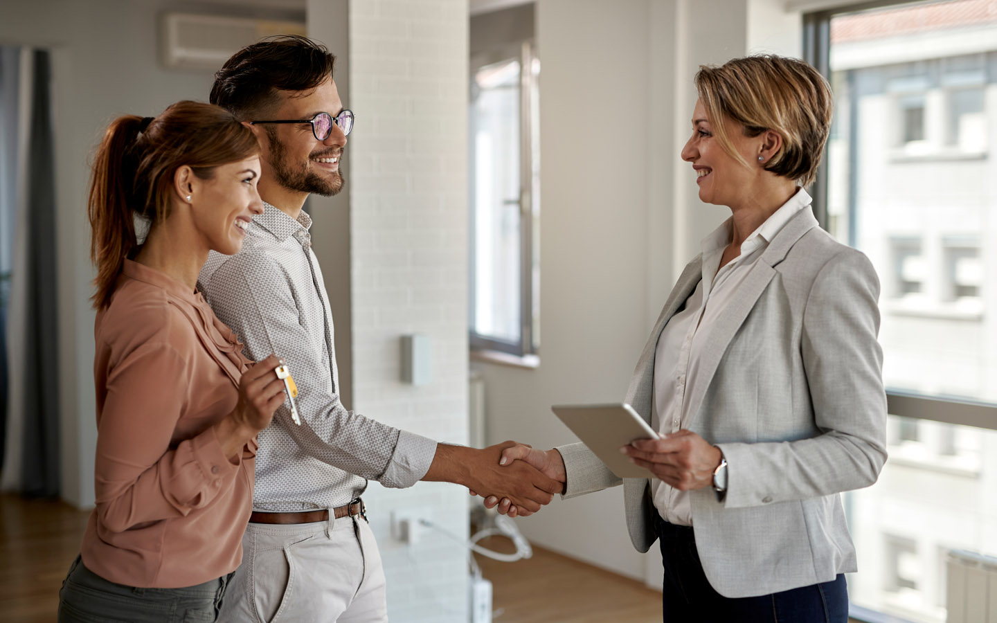 happy couple shaking hands and finalising deal with an agent