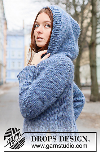 girl in blue hoodie in front of city scene