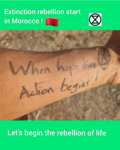 A close up of a Moroccan lower arm on which has been written 'When hope dies action begins!' with an XR symbol beside it