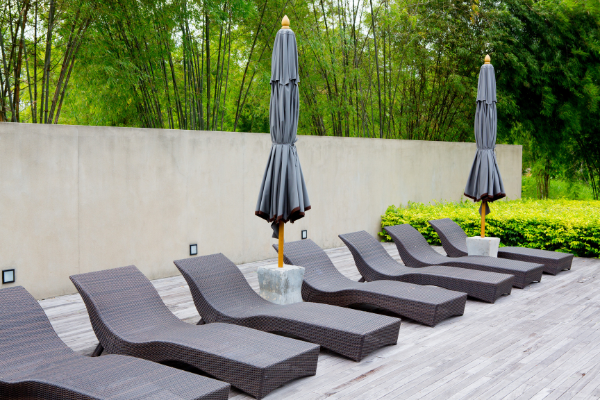 Modern poolside lounge chairs with two umbrellas