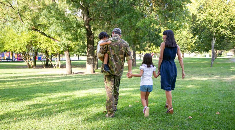 A U.S. Army soldier in uniform, walking in a Washington, D.C., park with his wife and children.