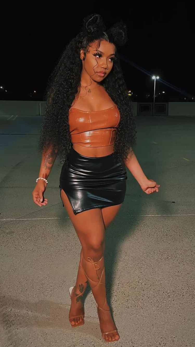 lady wearing leather brown top with leather black micro mini skirt