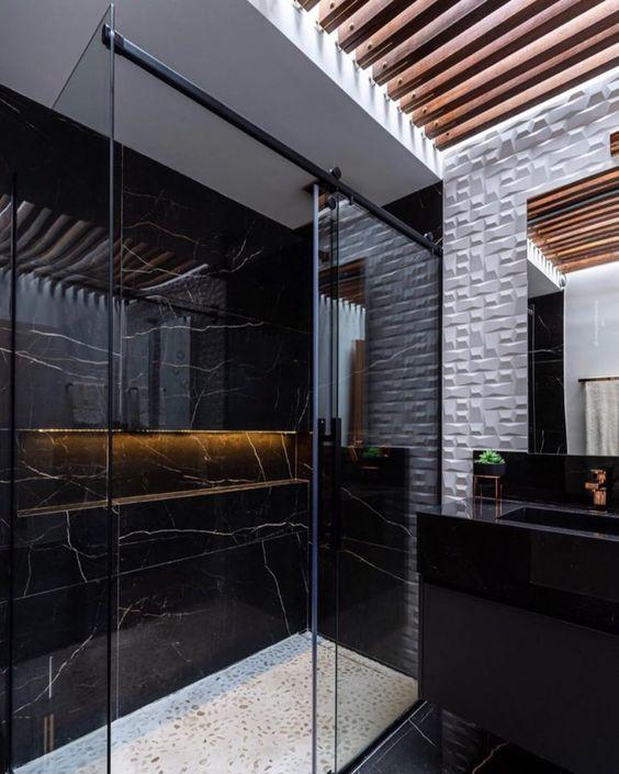banheiro em estilo moderno, optou por revestimento de porcelanato preto no box e azulejo 3D branco nas demais paredes e pia de granito preta