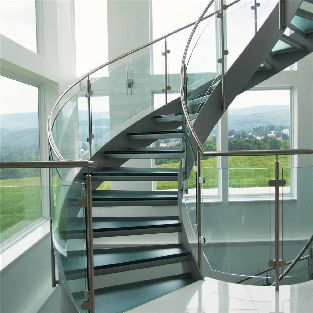 Modern staircase with curved glass barrier.