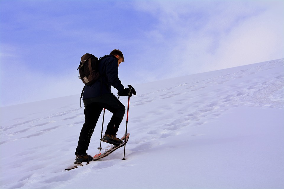 A man walking in snowshoes on a mountain