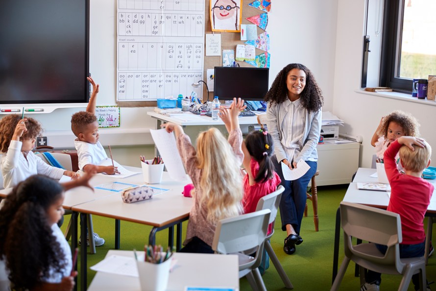 young children in a classroom with a teacher at the front of the class