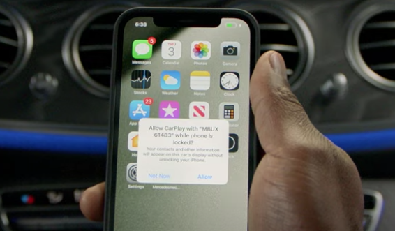 Hand holding iPhone with a message asking to allow CarPlay