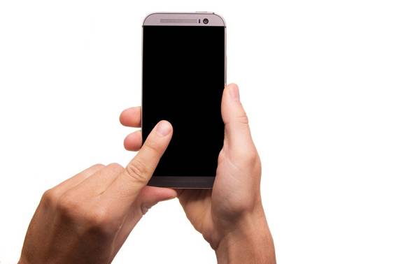 両手でスマートフォンを持っており左手人差し指で画面を指している
