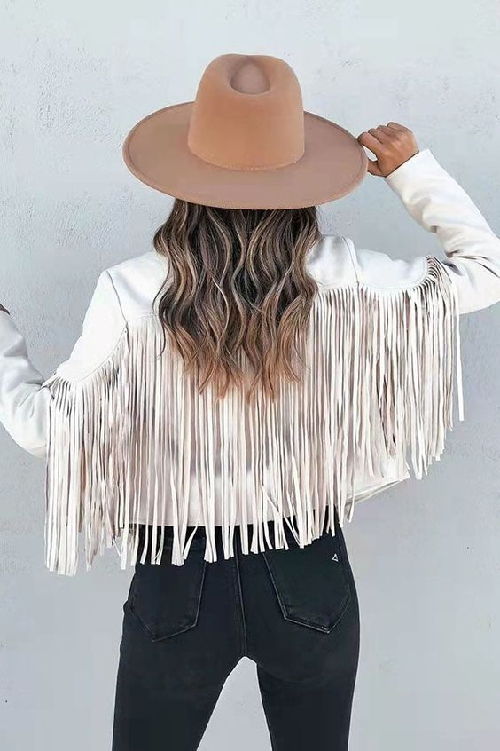 Back view woman wearing fringe jacket and cowgirl hat