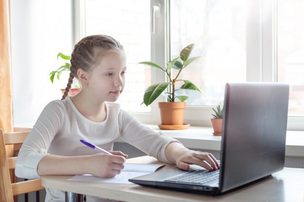 Schoolgirl studying at home using laptop. home school, online education, home education Premium Photo
