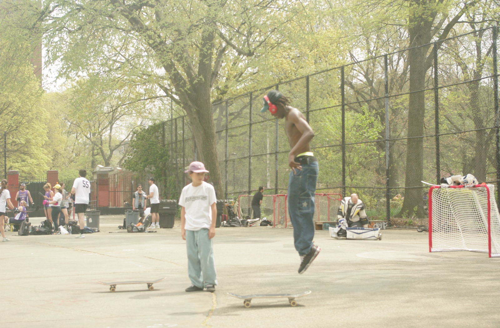 Two kids skating in a park.