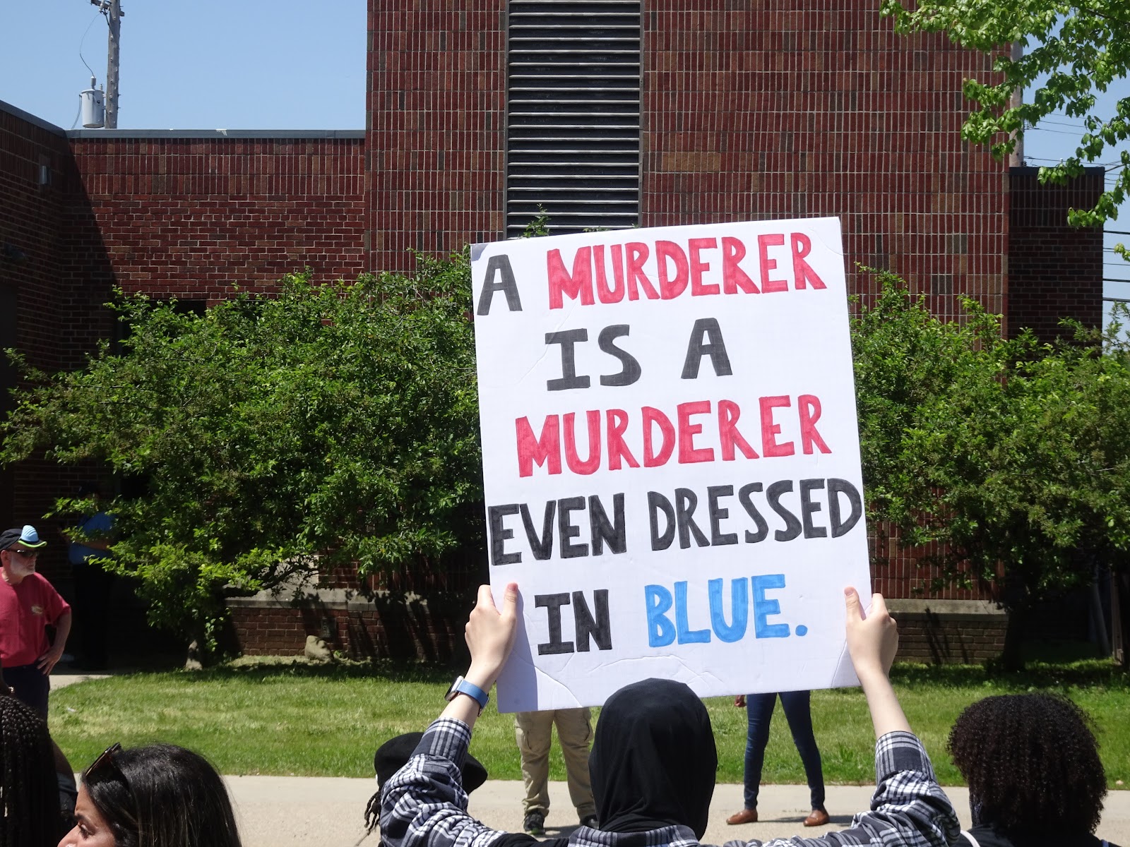 https://upload.wikimedia.org/wikipedia/commons/a/ae/A_murderer_is_a_murderer_-_George_Floyd_protests%2C_East_Lansing%2C_Michigan.jpg