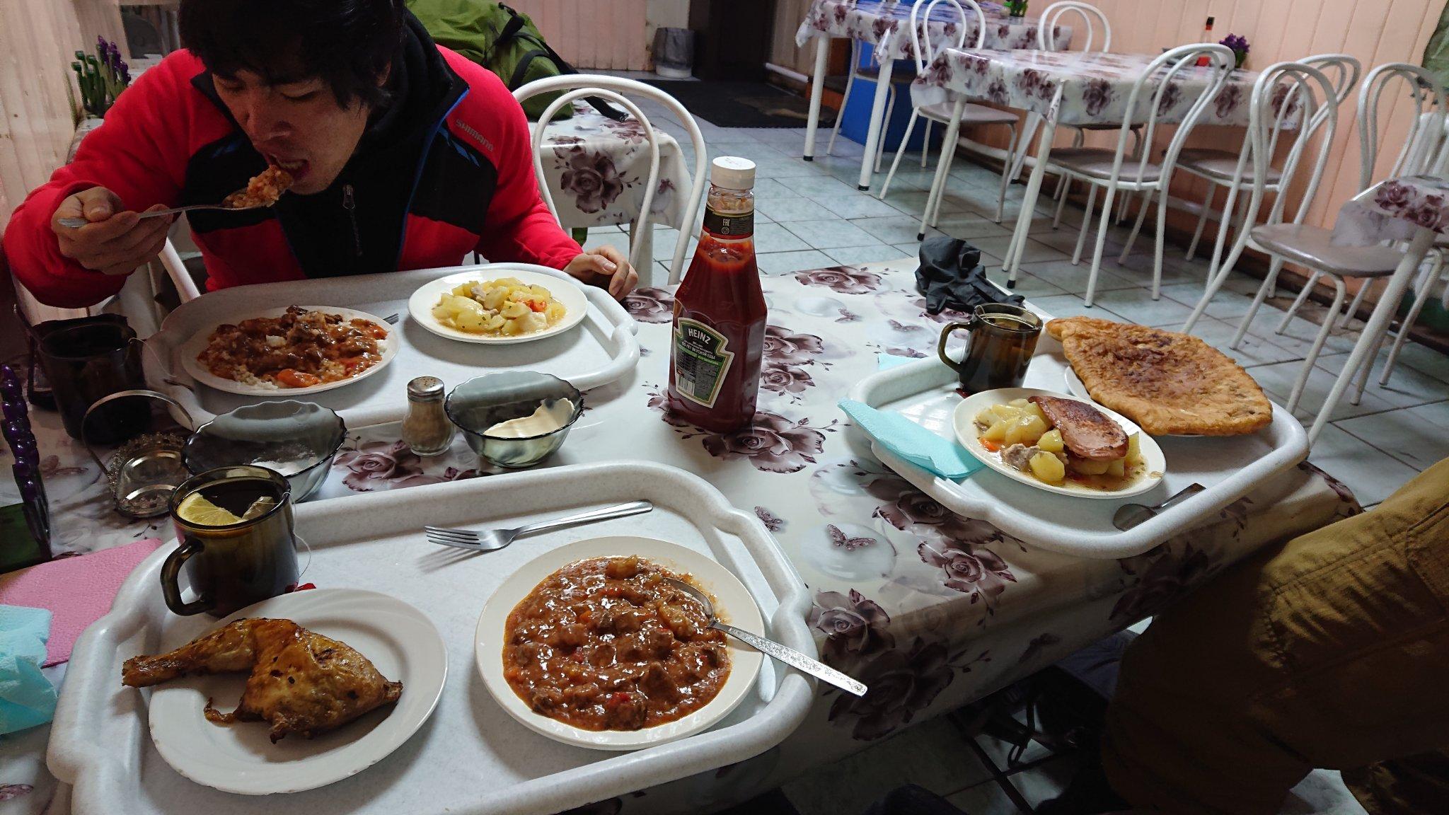 テーブルの上にある数種類の食事と男性

中程度の精度で自動的に生成された説明