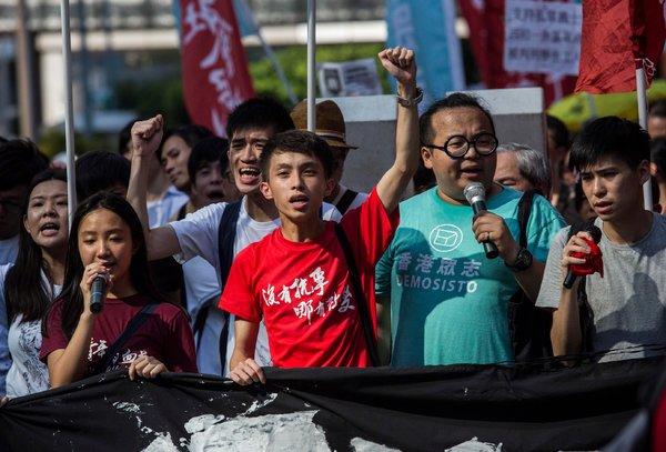 淳軒（右二）週日在香港參加遊行，抗議黃之鋒、羅冠聰和周永康入獄。