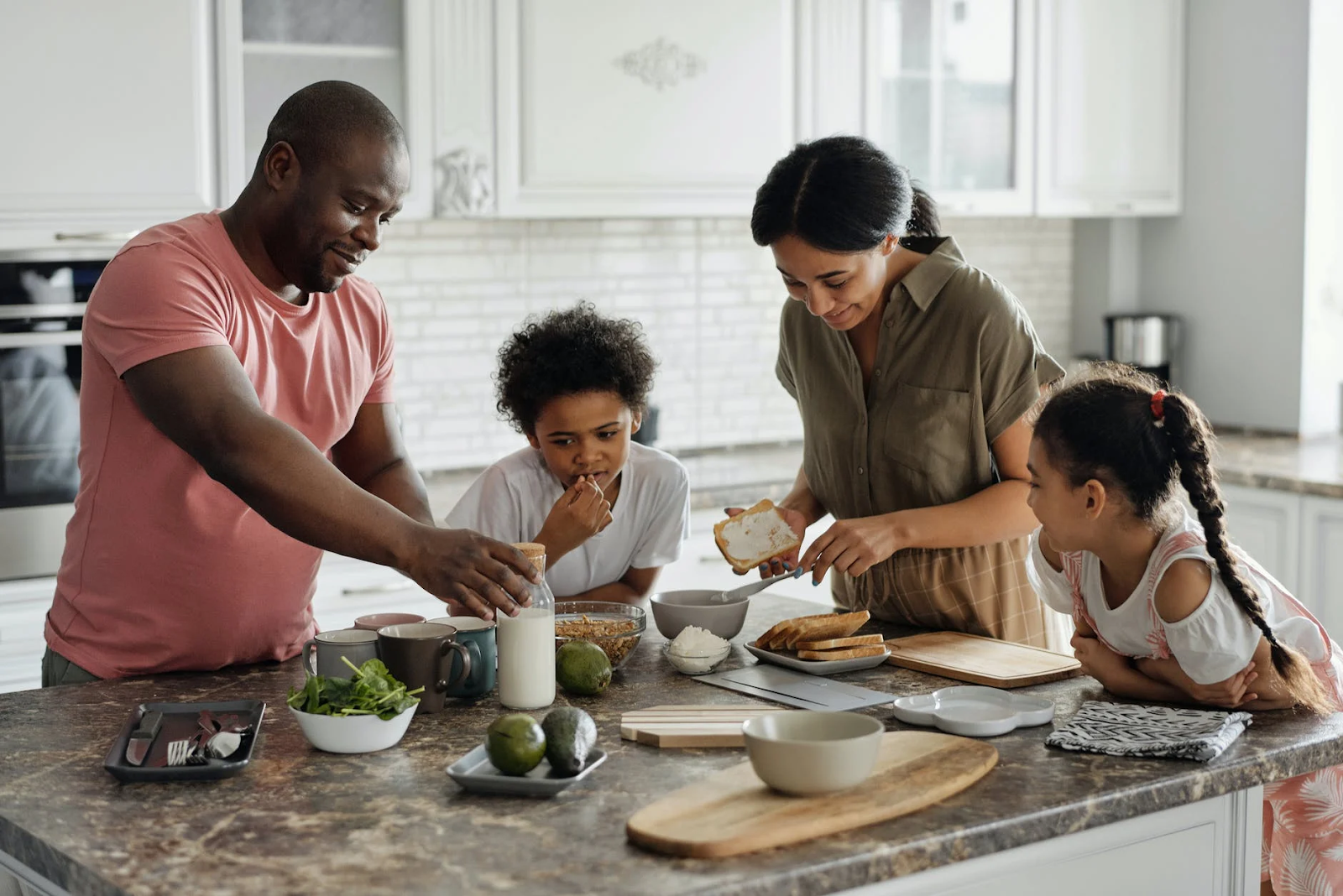 image shows two parents and two children cooking together