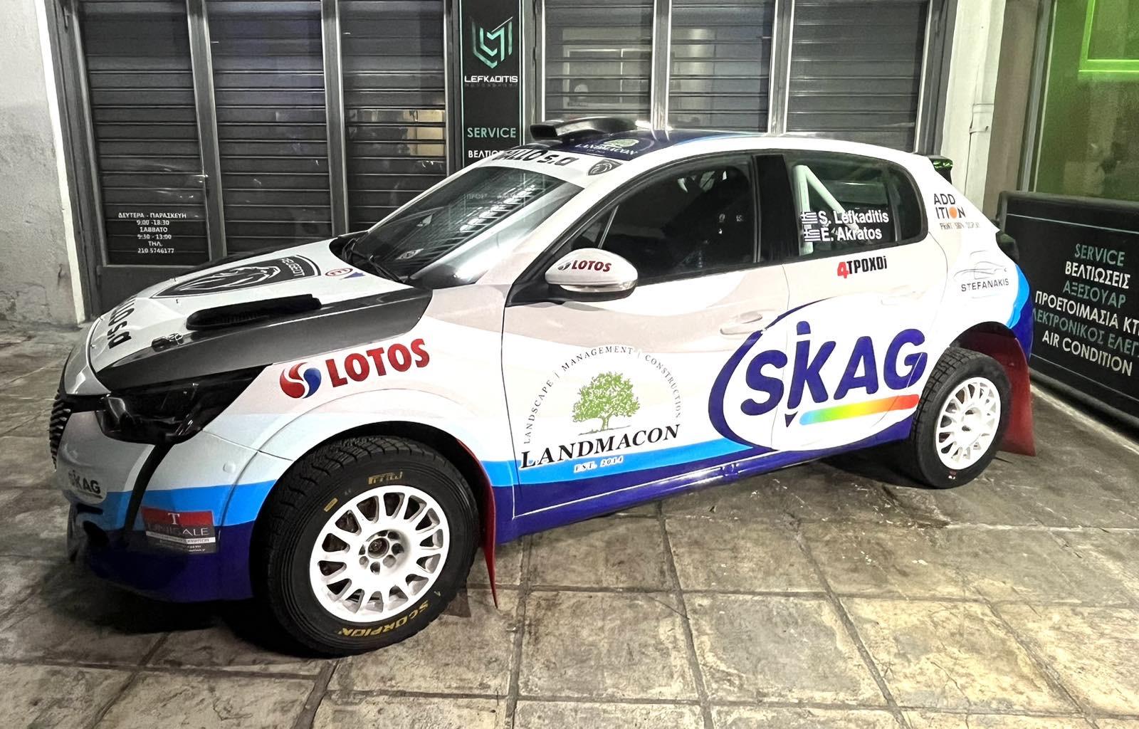 A white car with blue and white stripes

Description automatically generated