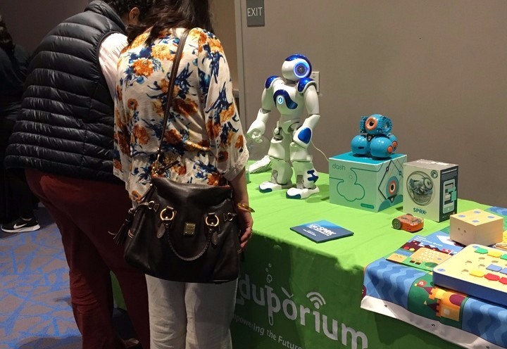 the nao robot and dash robot sitting on a conference table