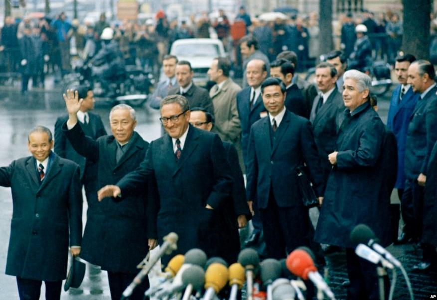 Cố vấn An ninh Quốc gia Mỹ Henry Kissinger (thứ ba từ trái), và cố vấn đặc biệt của phái đoàn Bắc Việt Nam Lê Đức Thọ (vẫy tay), được nhìn thấy sau cuộc họp cuối cùng của họ tại Trung tâm Hội nghị Quốc tế ở Paris, ngày 23 tháng 1 năm 1973.