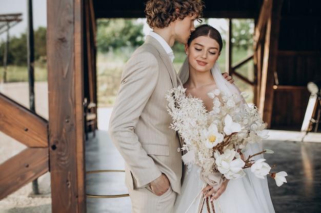 Jovem casal de noivos em seu casamento com buquê de casamento