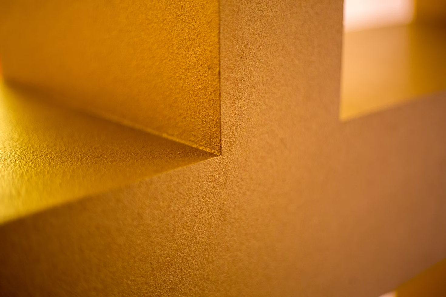 Closeup of a yellow wall and windowsill.